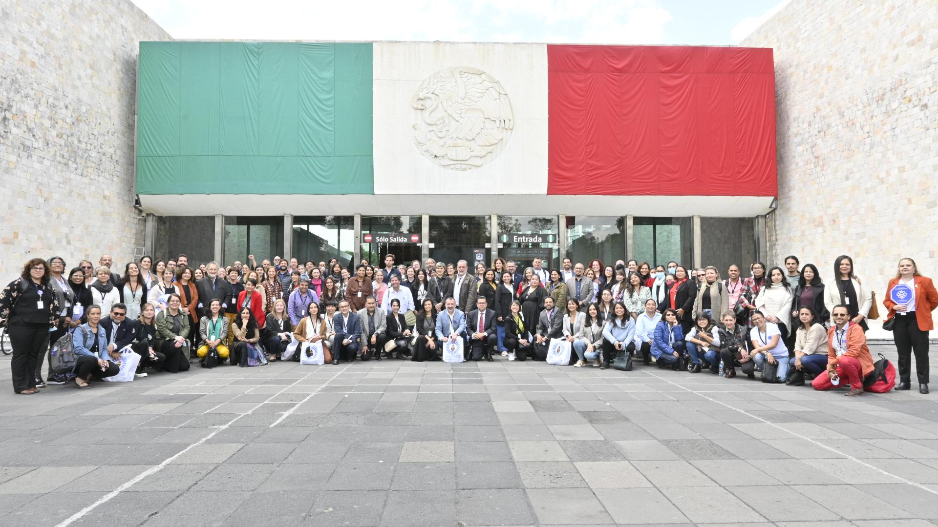 Grupo de personas posa en la entrada del Museo Nacional de Antropología, Ciudad de México, en el marco el 10º EIM.