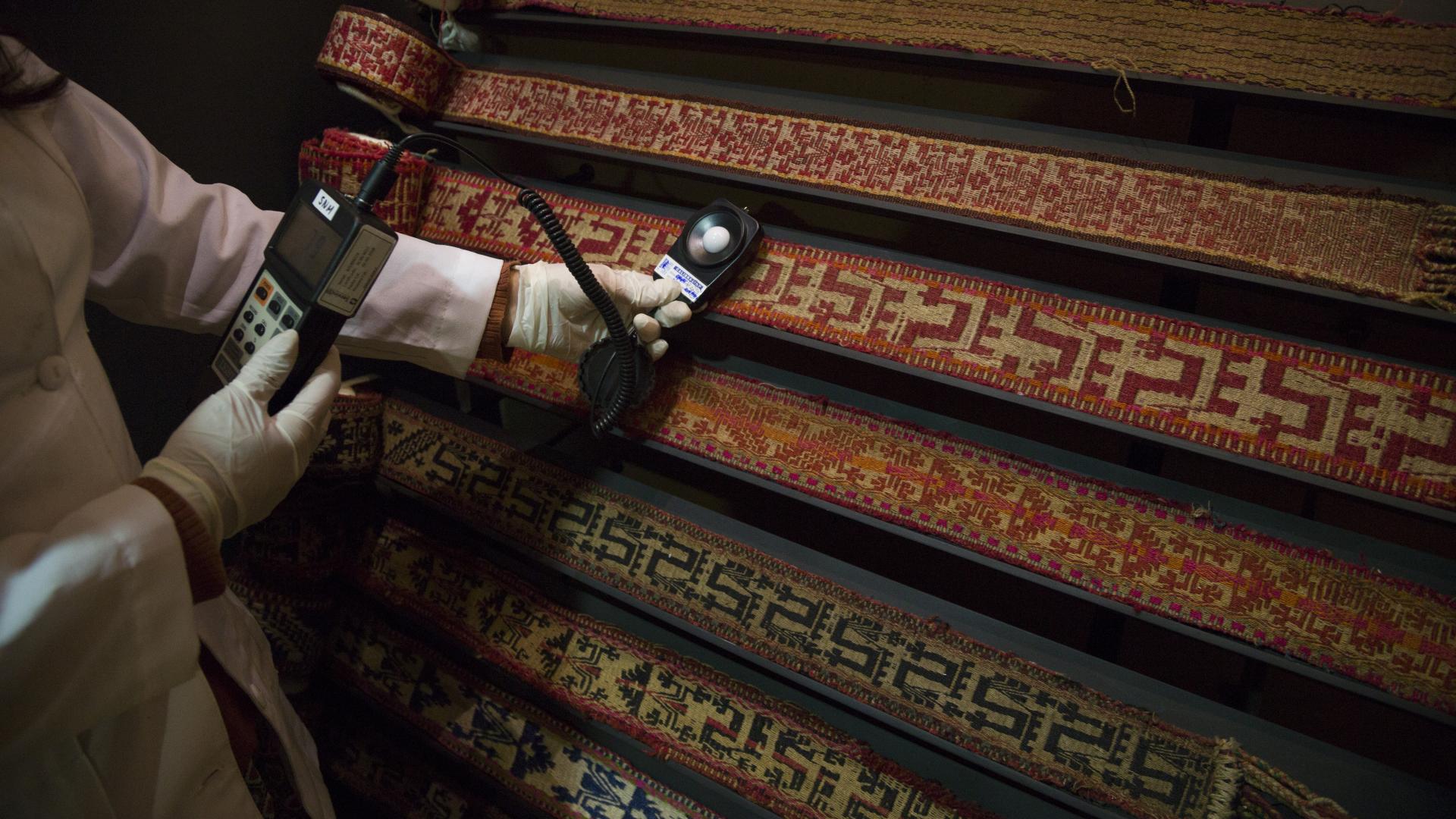 Trabajadora realiza mediciones en colección de trariwe mapuche