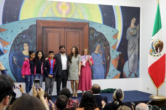 Foto de un grupo de personas, adultos y niños frente al mural que estaba siendo inaugurado. 