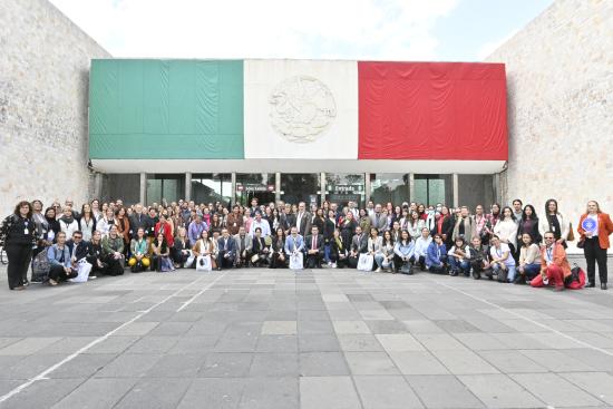 Grupo de personas posa en la entrada del Museo Nacional de Antropología, Ciudad de México, en el marco el 10º EIM.