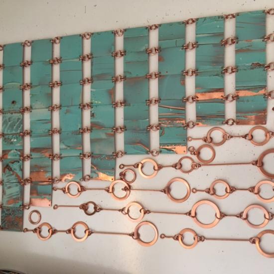 Tejido de láminas de cobre, compuesta de cuadrados en cobre oxidado, unidos a eslabones circulares de cobre pulido.